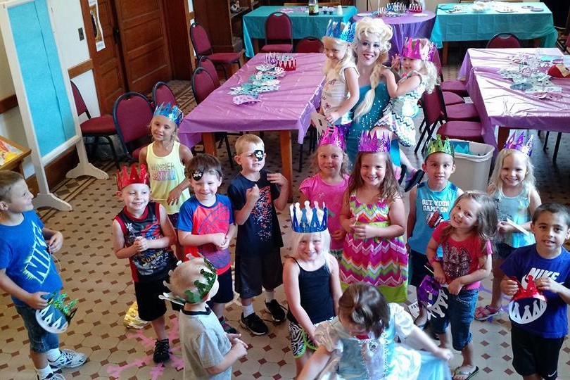 A group of kids pose with the Snow Queen at the Fairy Tale Ball.